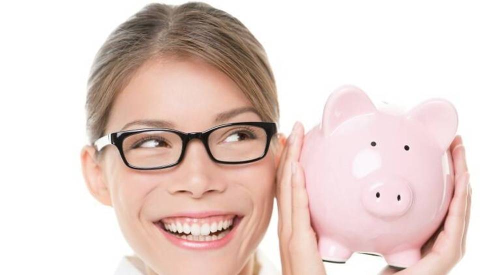 Woman smiling while holding piggy bank