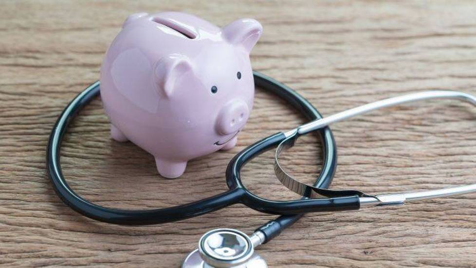 Piggy bank on table with stethoscope around it