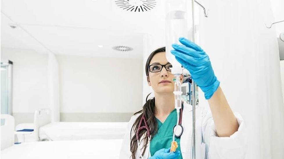 Healthcare worker checking fluids in drip line