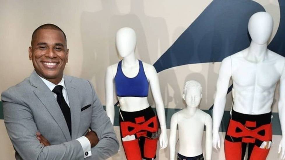 Man in suit posing with manikins wearing catheters