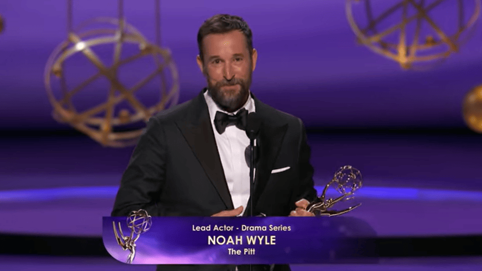 Noah Wyle holding Emmy award on stage after winning Lead Actor in a Drama Series for The Pitt.