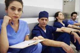 Group of tired and stressed healthcare workers in hospital hallway