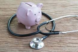 Piggy bank on table with stethoscope around it