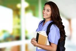 Nurse student with scrubs and backpack smiling