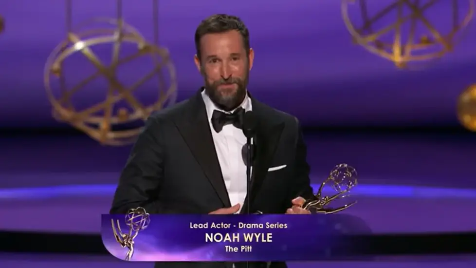 Noah Wyle holding Emmy award on stage after winning Lead Actor in a Drama Series for The Pitt.