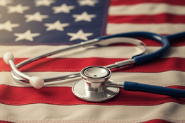 Stethoscope on an American flag, with a warm light from the left.