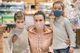 Mother with children wearing face masks at grocery store