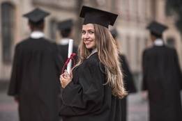 New graduate in robes holding diploma