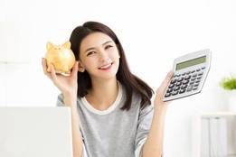 Woman holding calculator and piggy bank