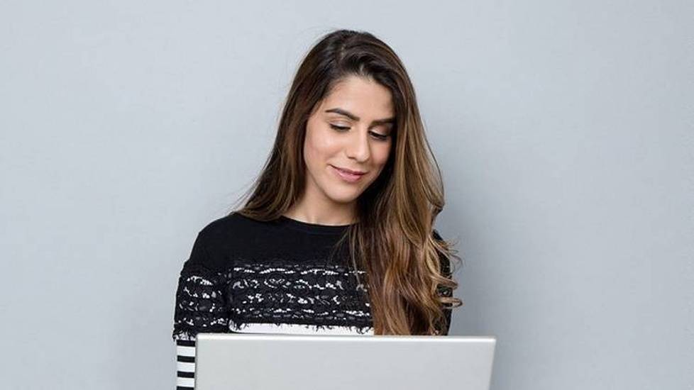Female student smiling while working on laptop computer