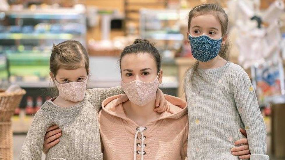 Mother with children wearing face masks at grocery store