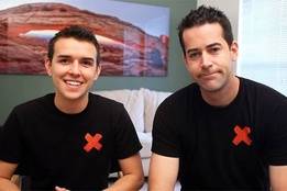 Two men in black shirts with red X over heart