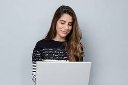 Female student smiling while working on laptop computer