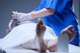Nurse checking on deceased patient in morgue
