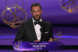 Noah Wyle holding Emmy award on stage after winning Lead Actor in a Drama Series for The Pitt.