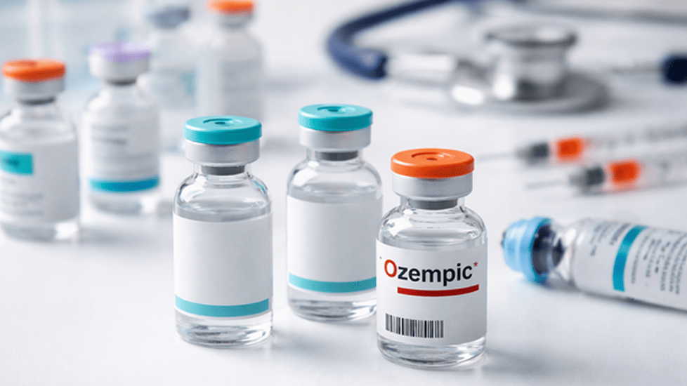 Close-up of injectable medication vials on a white clinical surface, with one vial standing out from the others to illustrate counterfeit drug concerns.